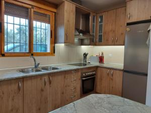 a kitchen with wooden cabinets and a stainless steel refrigerator at Cortijo Blanco in Albondón