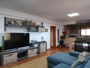 a living room with a blue couch and a flat screen tv at Cortijo Blanco in Albondón