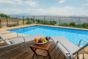 a bowl of fruit on a table next to a swimming pool at Vibe Naftali Estate in Ramot Naftali
