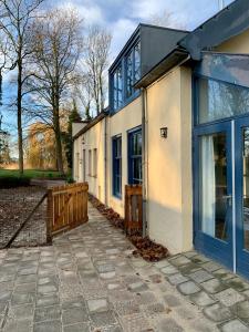 a house with a blue door and a fence at Koetshuis Buitenplaats Iepenoord in Oostkapelle