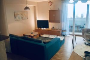 a living room with a blue couch and a tv at JASMINE APARTMENT - FREE PARKING - CITY CENTER - SKIBUS - TATRALANDIA 5km in Liptovský Mikuláš