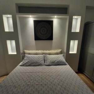 sypialnia z łóżkiem z obrazem na ścianie w obiekcie Enjoy Home w Genui