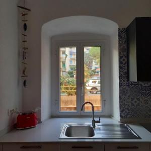 kuchnia ze zlewem i oknem w obiekcie Enjoy Home w Genui