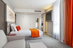 una camera d'albergo con letto e divano di Mercure Toulouse Sud a Tolosa