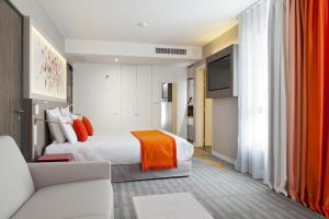 トゥールーズにあるMercure Toulouse Sudのベッドとソファ付きのホテルルーム