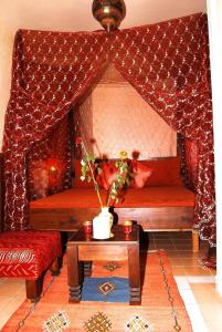 ein Wohnzimmer mit 2 Betten und einem Tisch in der Unterkunft Chez Peyo in Marrakesch