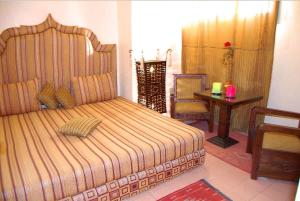 ein Schlafzimmer mit einem Bett, einem Tisch und einem Stuhl in der Unterkunft Chez Peyo in Marrakesch