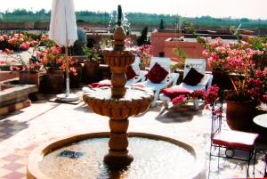 einen Brunnen mitten auf einem Innenhof mit Blumen in der Unterkunft Chez Peyo in Marrakesch