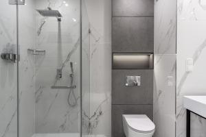 La salle de bains est pourvue d'une douche, de toilettes et d'un lavabo. dans l'établissement EL Apartments - Pollux, à Poznań