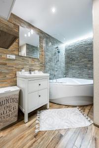 a bathroom with a white tub and a sink at Old Town Apartment Podtatranskeho in Košice