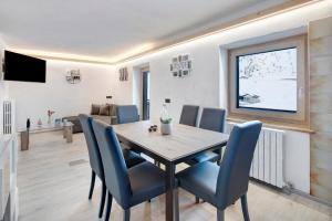 una sala da pranzo con tavolo e sedie blu di Appartamento Presot a Livigno