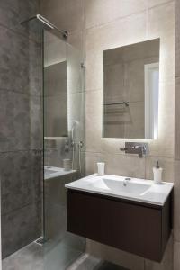 a bathroom with a sink and a glass shower at Voda Luxury Residence #401 in Athens