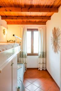 cocina con ventana y suelo de baldosa en Villetta Chia, en Chia
