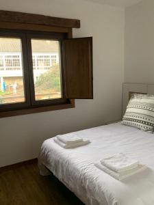 ein Schlafzimmer mit einem Bett mit zwei Handtüchern darauf in der Unterkunft Casa O Corvo, chalet cerca de Vigo en plena naturaleza 