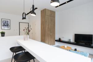 a kitchen with a white counter and two stools at Voda Luxury Residence #401 in Athens