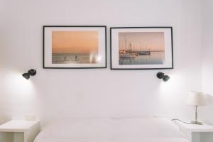 three pictures on a white wall above a bed at Apartamento Añoreta Malaga 318 in Torre de Benagalbón