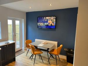 a dining room with a table and a tv on the wall at Luxury 2 bed Apartment in Stoke-on-Trent in Stoke on Trent