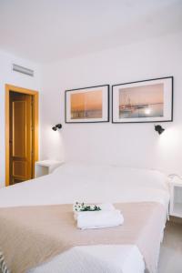 a white bedroom with a bed and two windows at Apartamento Añoreta Malaga 318 in Torre de Benagalbón