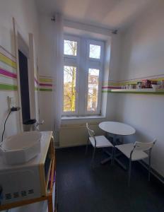 um quarto com uma mesa e cadeiras e uma janela em Studio confort Verviers em Verviers