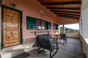 eine Veranda mit Stühlen, einer Tür und einem Tisch in der Unterkunft Villa Sea Edge in Orebić
