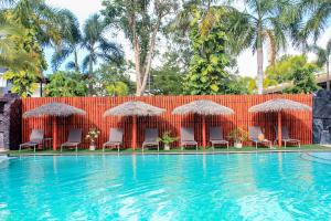 a resort swimming pool with chairs and umbrellas at Hideaway Resort Banchang in Ban Chang
