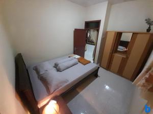 سرير أو أسرّة في غرفة في Marry Ind Gunung Kawi Guest House Malang
