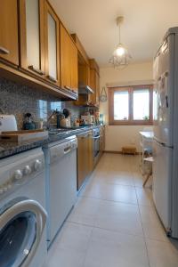 a large kitchen with a washer and dryer in it at Lua do Mar - T2 - Piscina - Fte ao Mar- Central in Nazaré