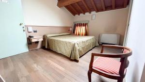 a bedroom with a bed and a desk and a chair at Possessioni Ferraresi in Melara
