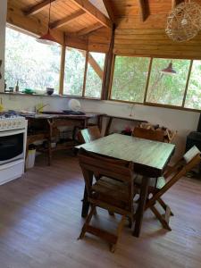 una cocina con mesa y sillas en una cabaña en Casa Oniria en Villa Las Rosas