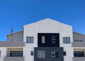 a white building with a blue sky in the background at Ongwe Leisure Property in Swakopmund