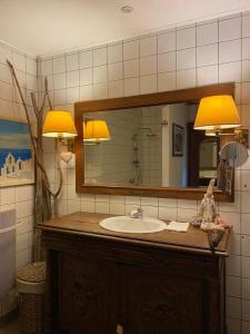 a bathroom with a sink and a mirror at Gîte Les Truffières in Trémolat