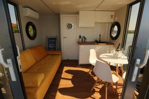 a living room with a couch and a table and a kitchen at Houseboat in Wolin