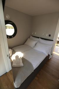 uma cama num pequeno quarto com uma janela em Houseboat em Wolin