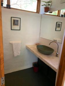 baño con lavabo verde y espejo en Casa Oniria en Villa Las Rosas