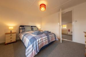 1 dormitorio con 1 cama con manta azul y blanca en The Town House en Woodbridge
