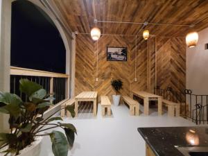 Habitación con paredes de madera, mesas y bancos en Lightning House, en Da Lat
