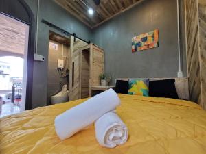 a yellow bed with a roll of towels on it at Lightning House in Da Lat