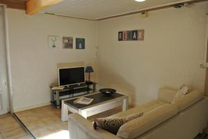 een woonkamer met een bank en een tv bij La Batisse in Saint-Laurent