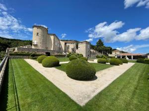 Um edifício com um monte de arbustos à frente. em Château de Cachard em Boffres