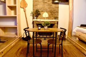 una mesa y sillas en una habitación con una pared de ladrillo en Νύμφες Σαλέ Ιαίρα, 