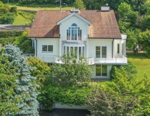 uma vista aérea de uma casa branca com um telhado vermelho em Ferienwohnung am Bodensee mit Seesicht und Wellness em Rorschacherberg