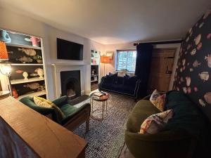 a living room with two chairs and a fireplace at No33 THORNHAM BOUTIQUE COTTAGE 3 in Thornham