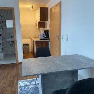 a kitchen with a table and chairs in a room at 1 Zimmer Apartment DG in Eislingen