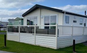 莫克姆LA07 Oceanview的一座白色的小房子,四周有围栏