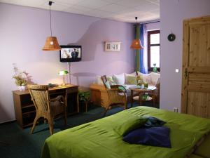 a bedroom with a bed and a living room at Hermanns Hotel Zum Goldenen Stern in Jüterbog