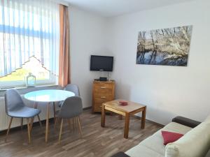 un piccolo soggiorno con tavolo e TV di Seevilla Wietjes Whg 3 a Baltrum