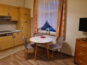 eine Küche mit einem Tisch und Stühlen sowie einem Fenster in der Unterkunft Seevilla Wietjes Whg 3 in Baltrum