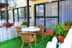a patio with a table and chairs and flowers at LUCA Apartments in Saturn