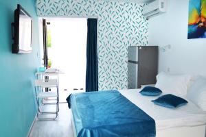a bedroom with a bed with blue sheets and a window at LUCA Apartments in Saturn