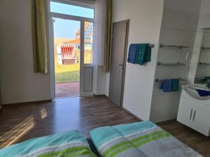 een kamer met een bed, een wastafel en een deur bij Seevilla Wietjes Whg 3 in Baltrum